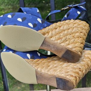 Soles of the Louis Vuitton printed raffia wedge sandals shown for condition