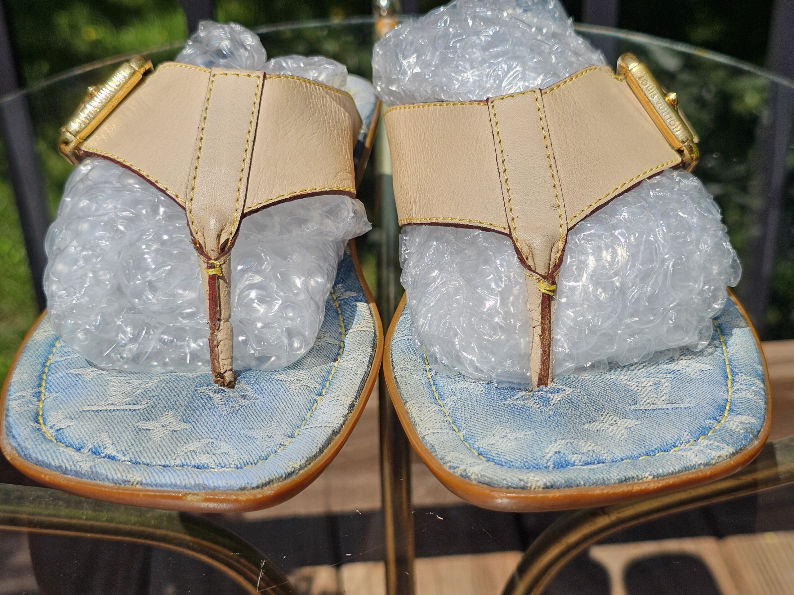 Front view of the Louis Vuitton Monogram denim thong sandals showing the toe posts and leather straps