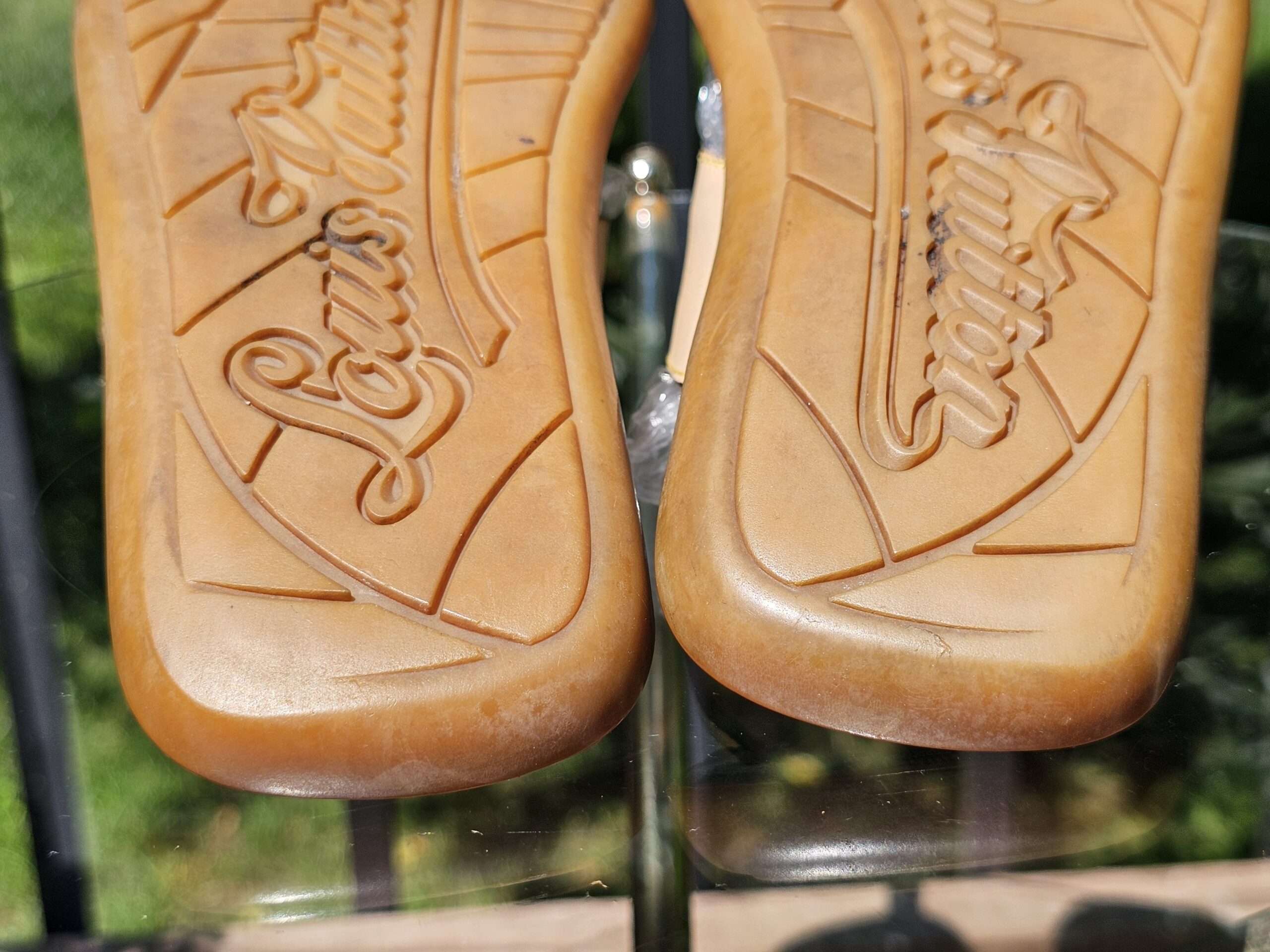 Close-up of the Louis Vuitton embossed leather soles showing normal wear from use