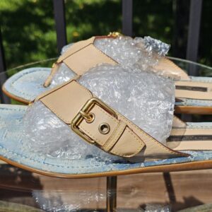 Natural leather T-straps and gold-tone buckles on the Louis Vuitton Monogram denim thong sandals