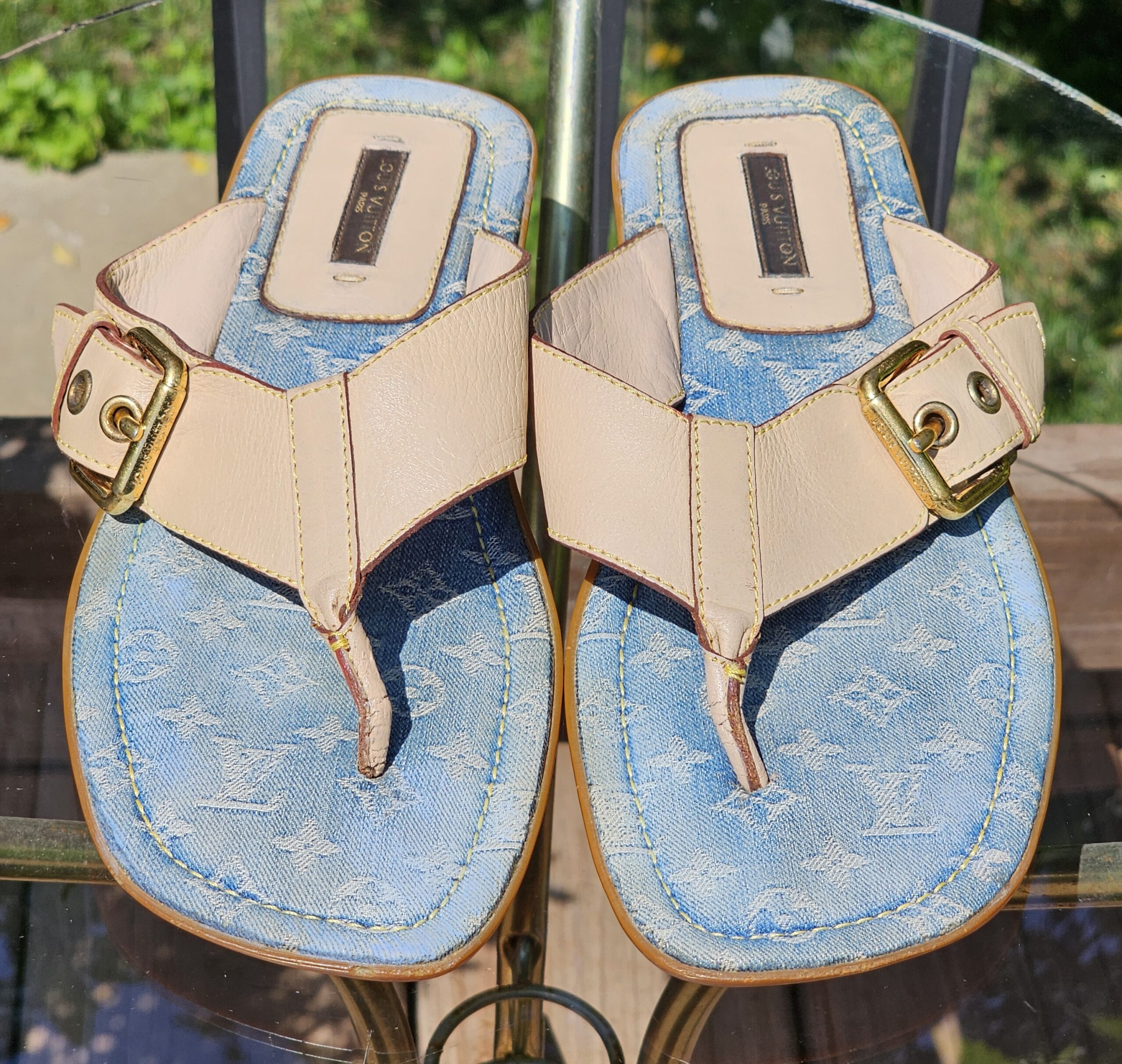 Pair of Louis Vuitton Monogram denim thong sandals photographed from above showing both footbeds
