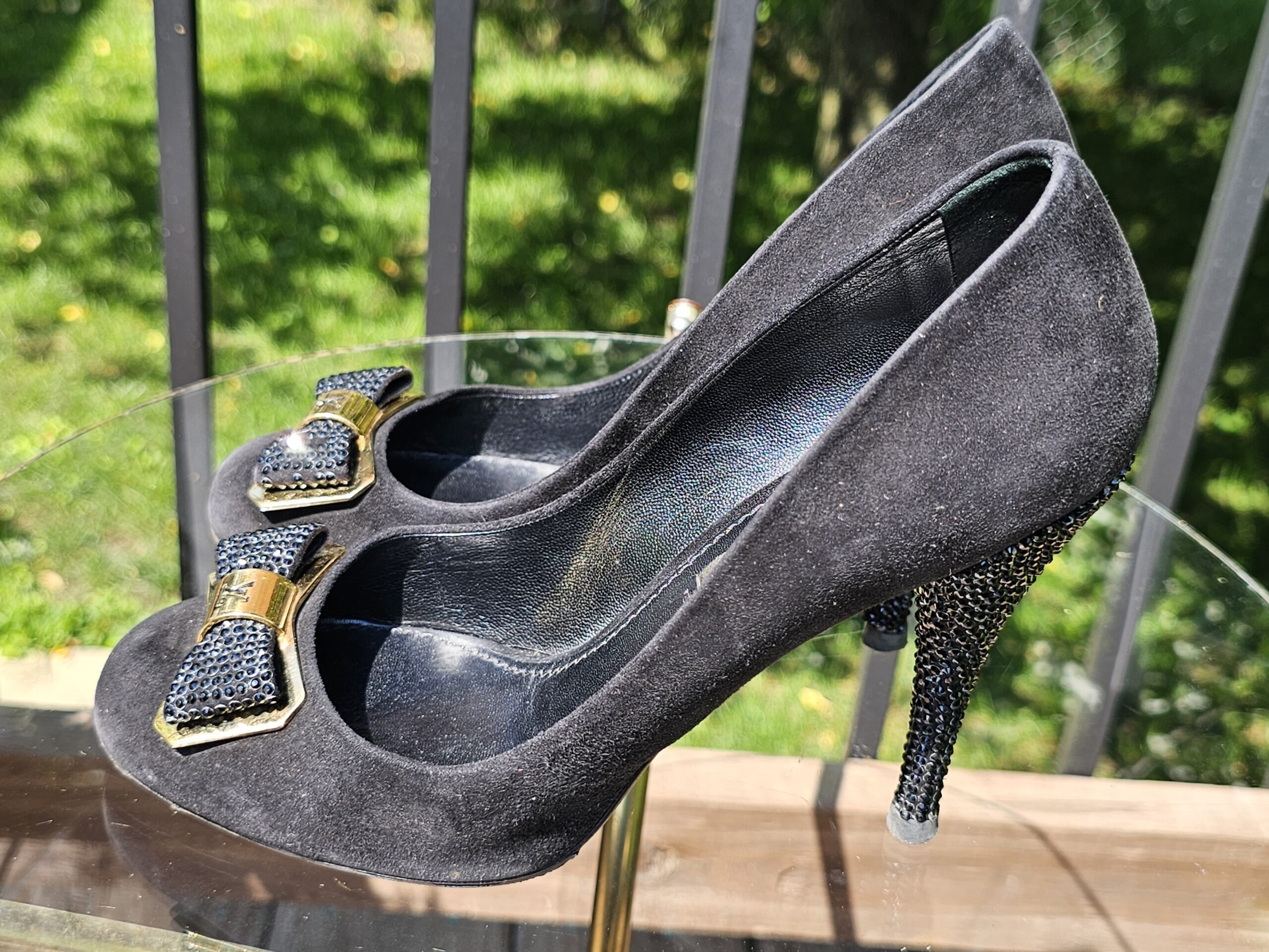 Suede uppers of the Louis Vuitton crystal bow pumps shown for condition with rubbing and marks from use