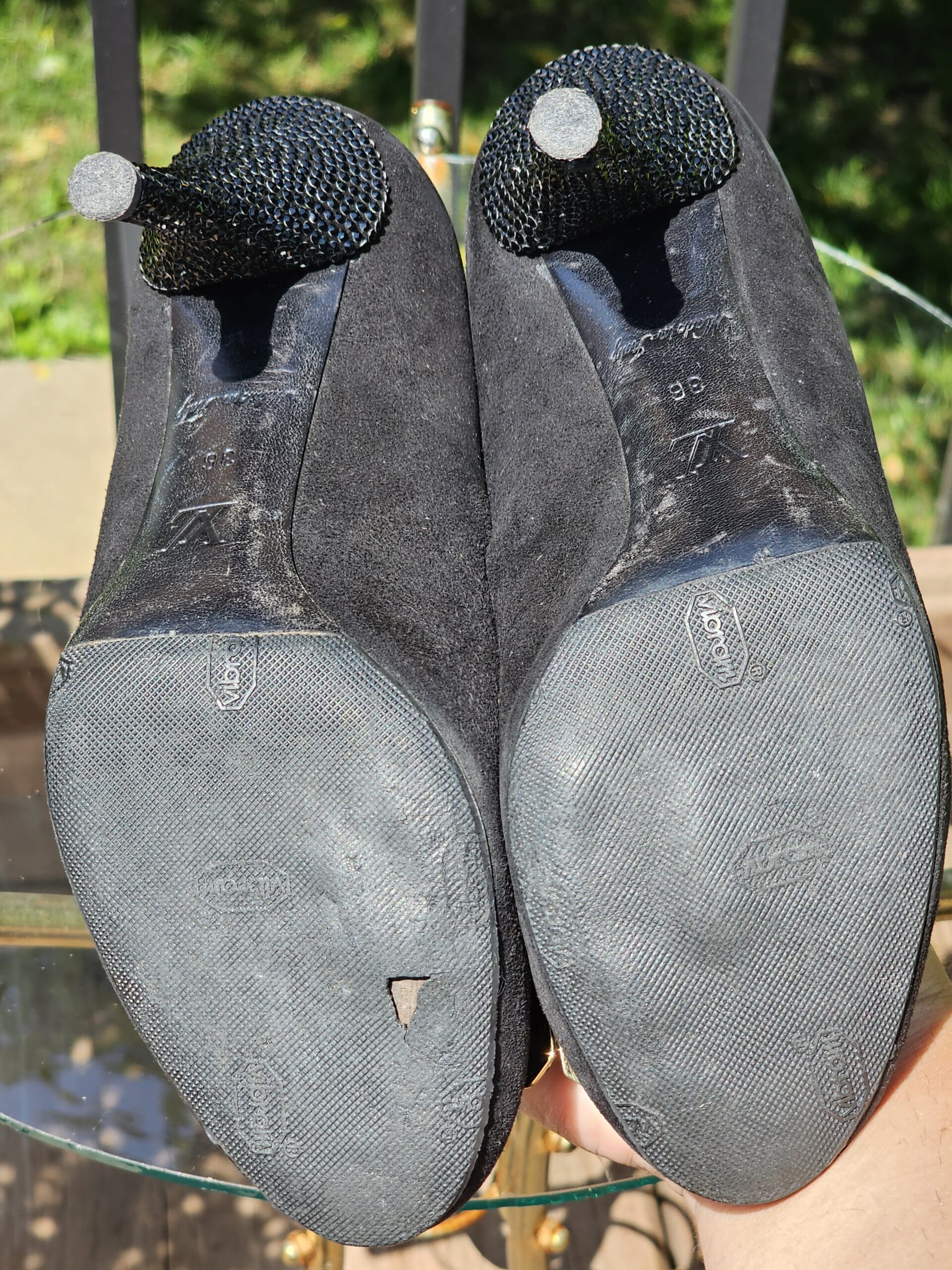 Soles and heel tips of the Louis Vuitton crystal embellished bow suede pumps shown for wear
