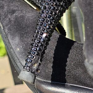 Close-up of the crystal covered stiletto heel on the Louis Vuitton suede pumps showing missing crystals