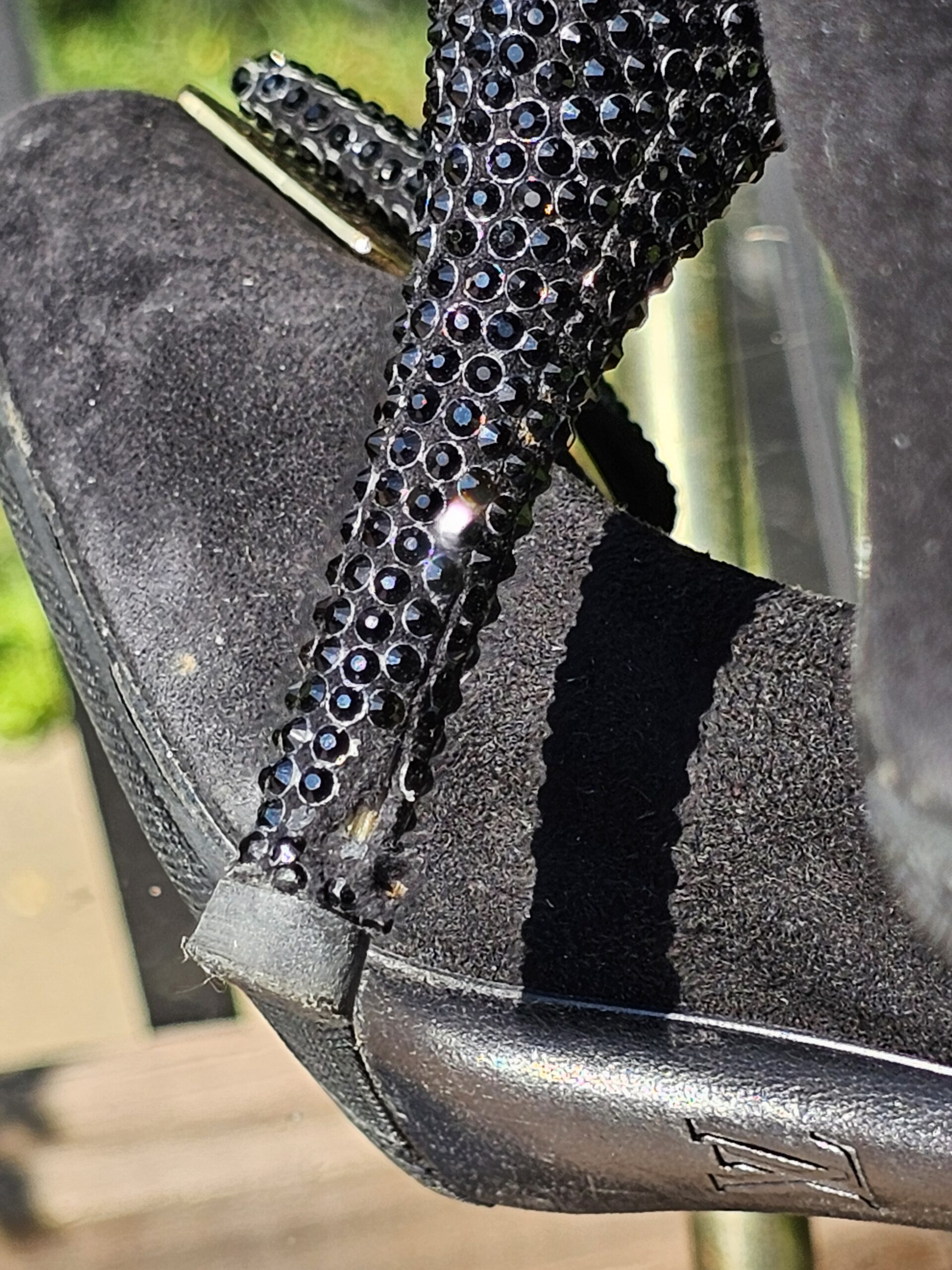 Close-up of the crystal covered stiletto heel on the Louis Vuitton suede pumps showing missing crystals