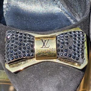 Close-up of the crystal bow and gold-tone LV hardware on the Louis Vuitton suede pumps