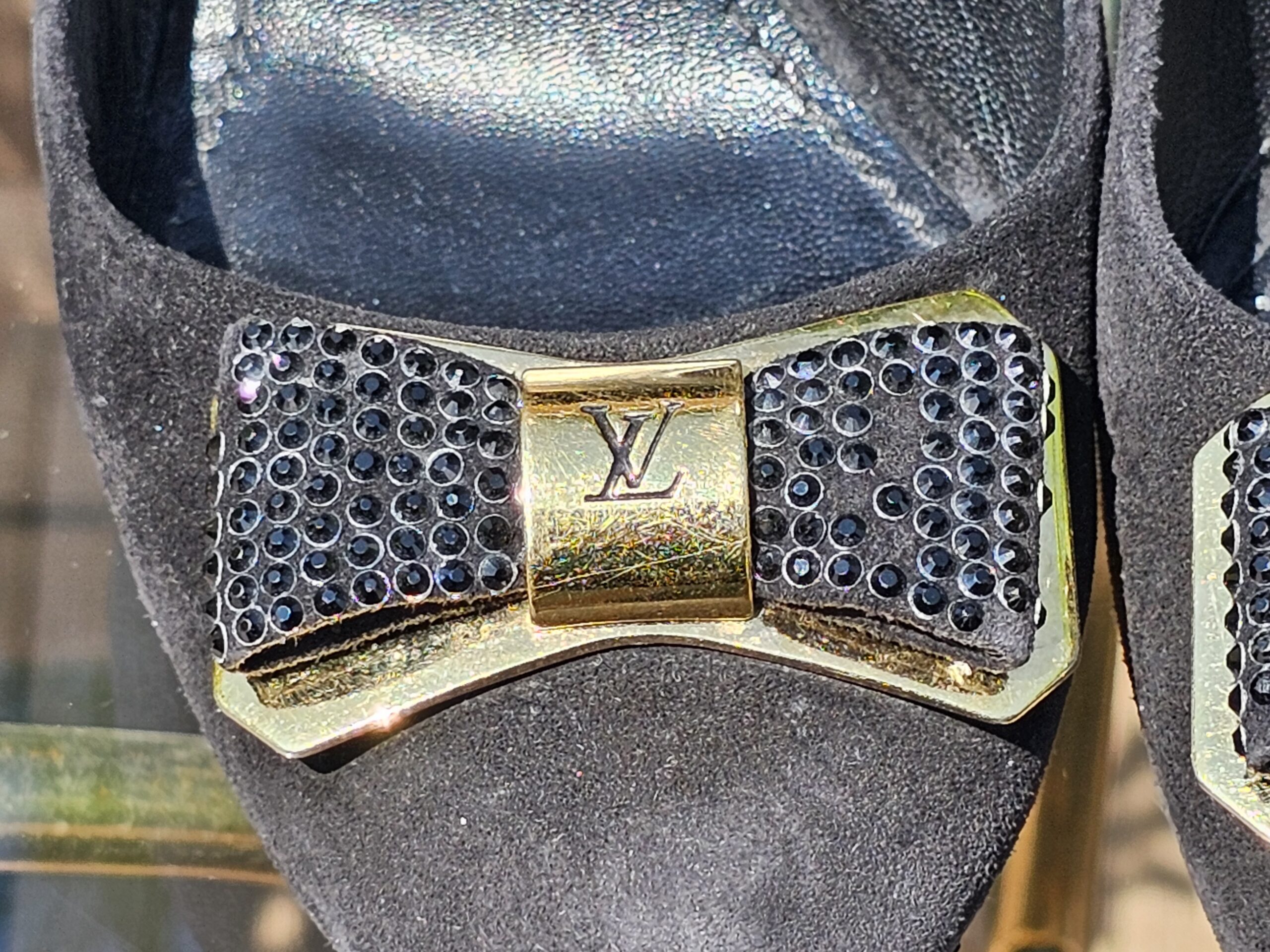 Close-up of the crystal bow and gold-tone LV hardware on the Louis Vuitton suede pumps