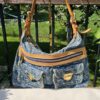 Louis Vuitton Baggy PM in blue Monogram denim shown hanging by its vachetta strap above the Louis Vuitton dust bag