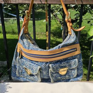 Louis Vuitton Baggy PM in blue Monogram denim shown hanging by its vachetta strap above the Louis Vuitton dust bag