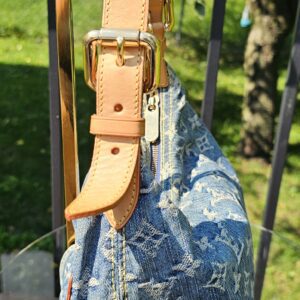 Adjustable vachetta strap of the Louis Vuitton Monogram Denim Baggy PM shown at full drop