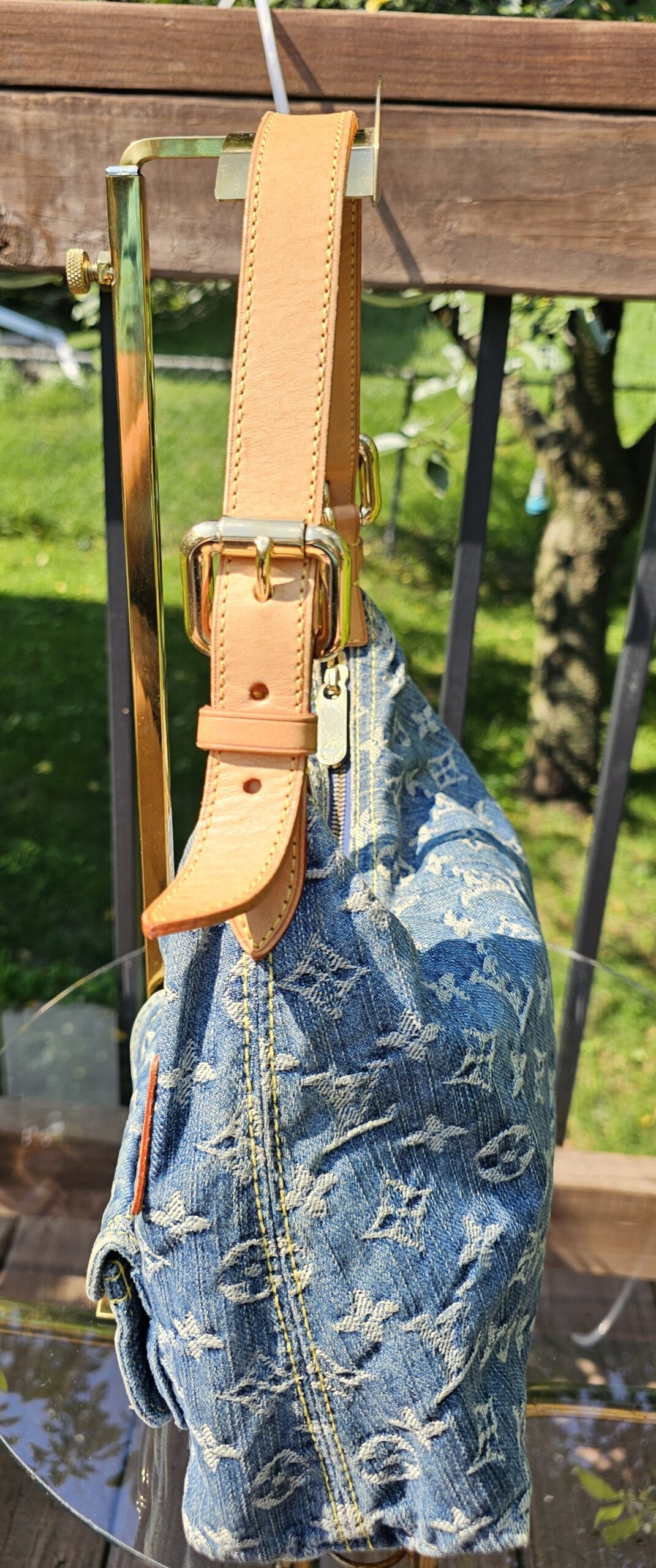 Adjustable vachetta strap of the Louis Vuitton Monogram Denim Baggy PM shown at full drop