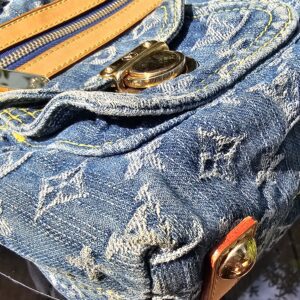 Exterior zip pocket and flap pocket detail on the Louis Vuitton Monogram Denim Baggy PM