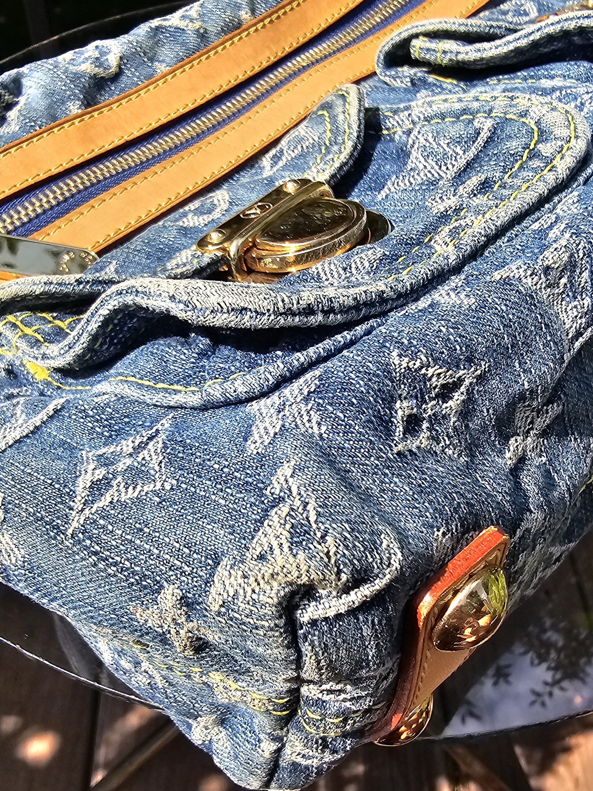 Exterior zip pocket and flap pocket detail on the Louis Vuitton Monogram Denim Baggy PM