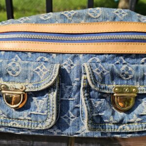 Louis Vuitton Monogram Denim Baggy PM laid flat showing the zip pocket above two flap pockets