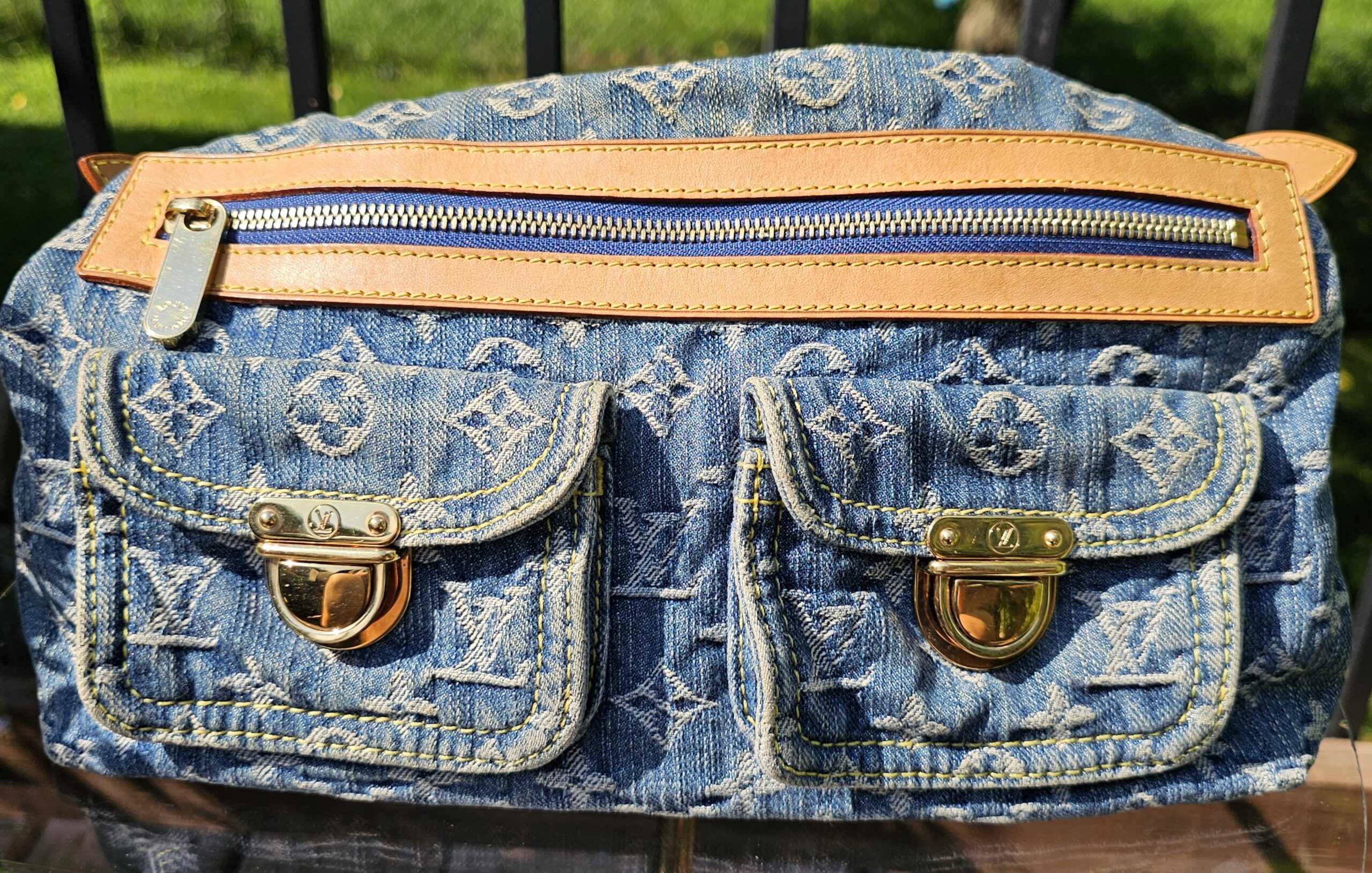 Louis Vuitton Monogram Denim Baggy PM laid flat showing the zip pocket above two flap pockets