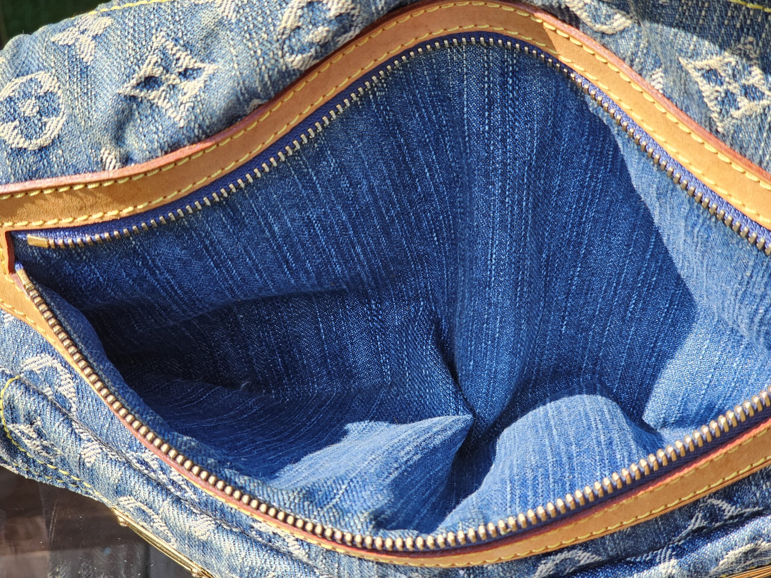 Open zip top of the Louis Vuitton Monogram Denim Baggy PM showing the denim exterior and lined interior