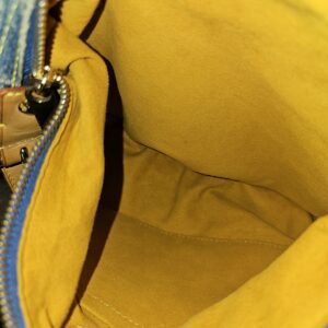Interior slip pocket of the Louis Vuitton Monogram Denim Baggy PM in yellow lining