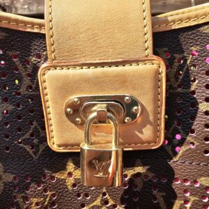 Vachetta flap and gold-tone LV lock closure on the front of the Louis Vuitton Monogram Perforated Musette