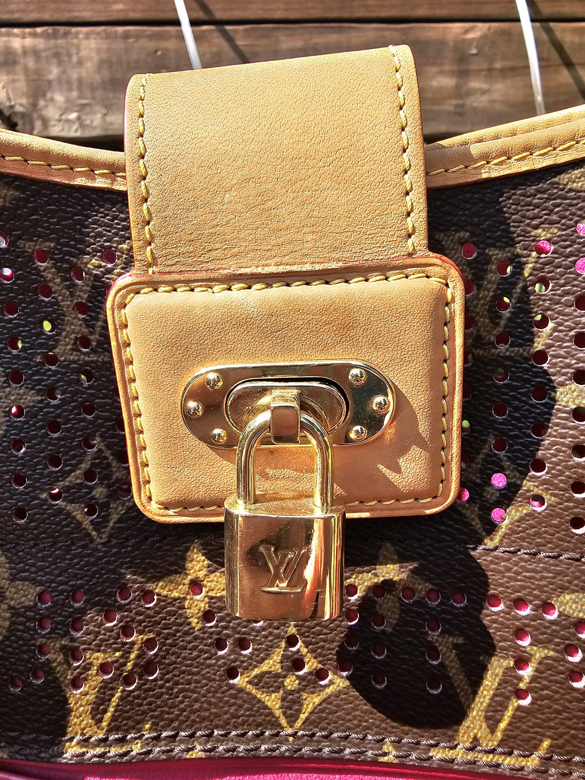 Vachetta flap and gold-tone LV lock closure on the front of the Louis Vuitton Monogram Perforated Musette