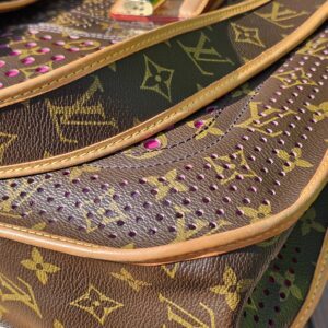 Perforated Monogram canvas of the Louis Vuitton Musette with fuchsia leather visible through the cut-outs