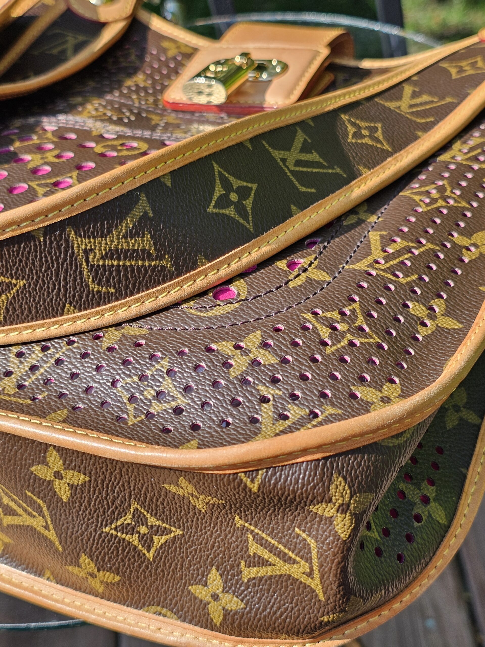 Perforated Monogram canvas of the Louis Vuitton Musette with fuchsia leather visible through the cut-outs