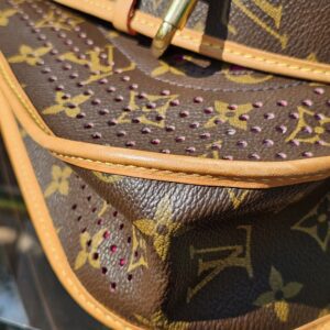 Side of the Louis Vuitton Monogram Perforated Musette showing the perforated panel meeting the vachetta trim