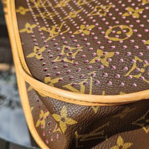 Vachetta trim on the Louis Vuitton Monogram Perforated Musette showing patina and creasing from previous use