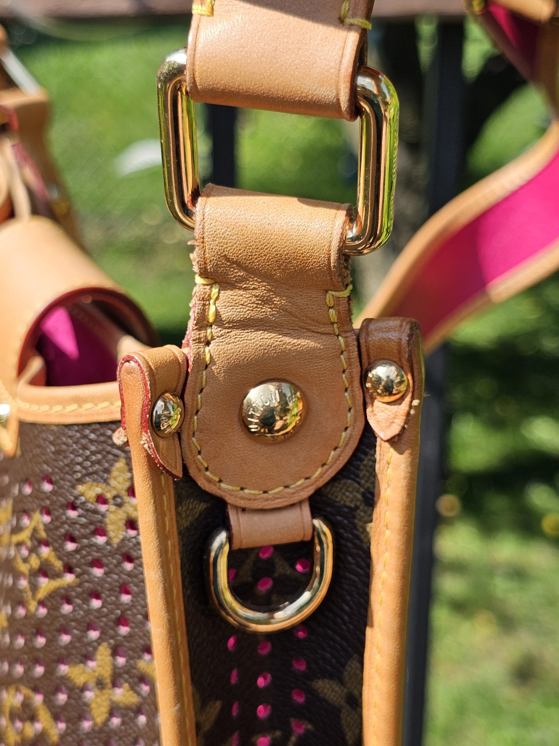 Gold-tone ring and vachetta tab where the strap attaches to the Louis Vuitton Monogram Perforated Musette