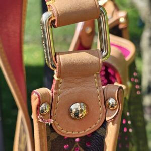 Close-up of the upper side hardware on the Louis Vuitton Monogram Perforated Musette showing wear and fraying to the leather tab