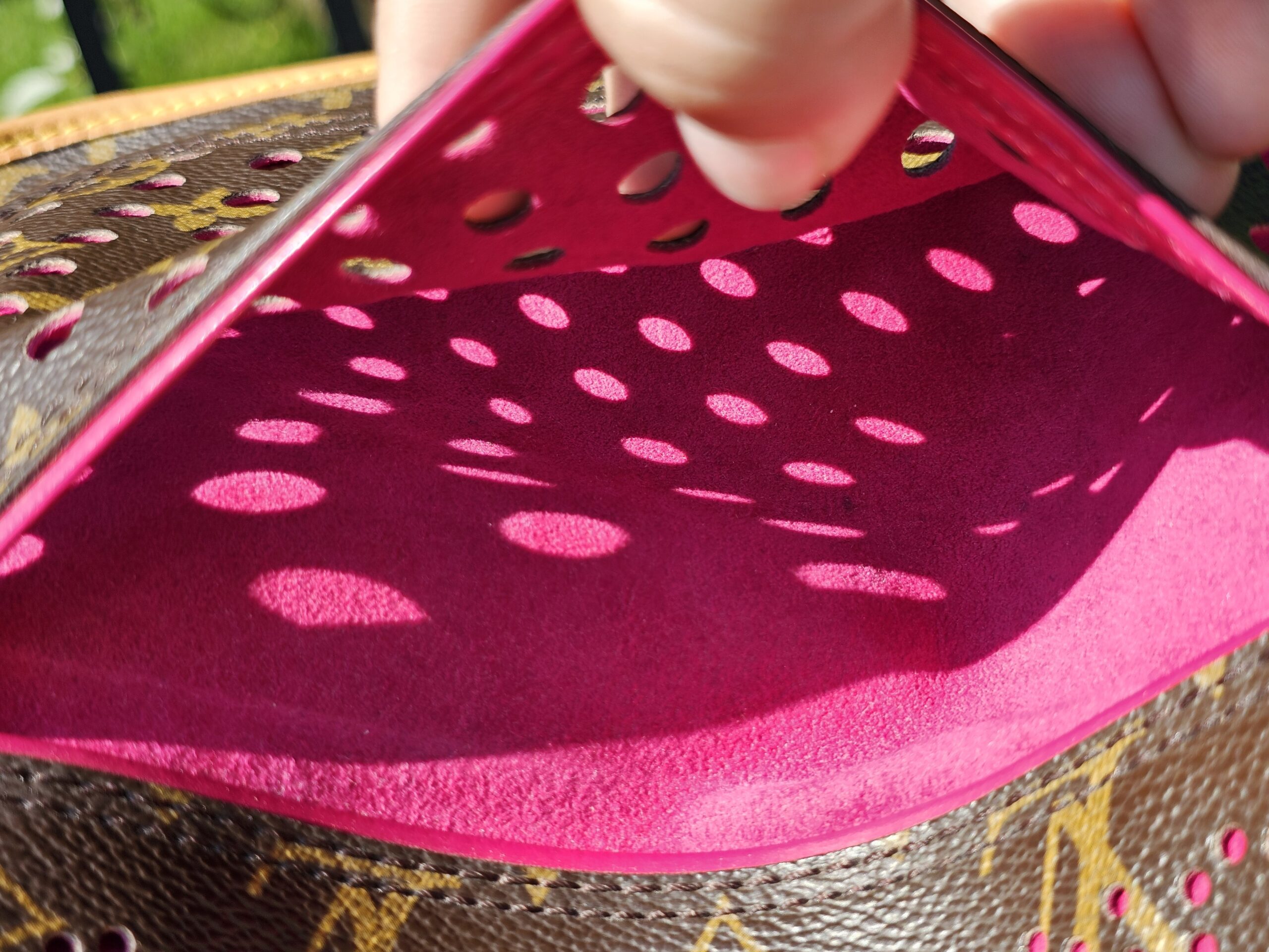 Bright fuchsia perforated leather panel inside the Louis Vuitton Monogram Perforated Musette