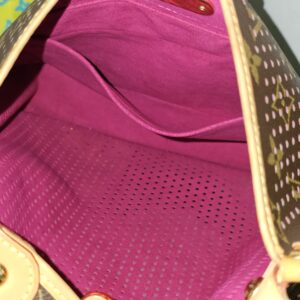 Interior of the Louis Vuitton Monogram Perforated Musette showing the fuchsia lining and slip pocket