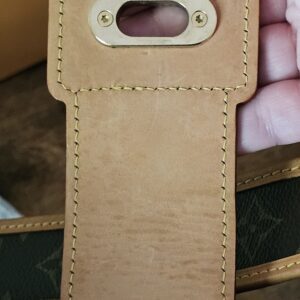 Underside of the vachetta flap on the Louis Vuitton Monogram Perforated Musette showing the lock plate