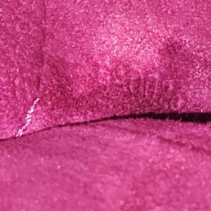 Close-up of the fuchsia interior of the Louis Vuitton Monogram Perforated Musette showing light signs of use