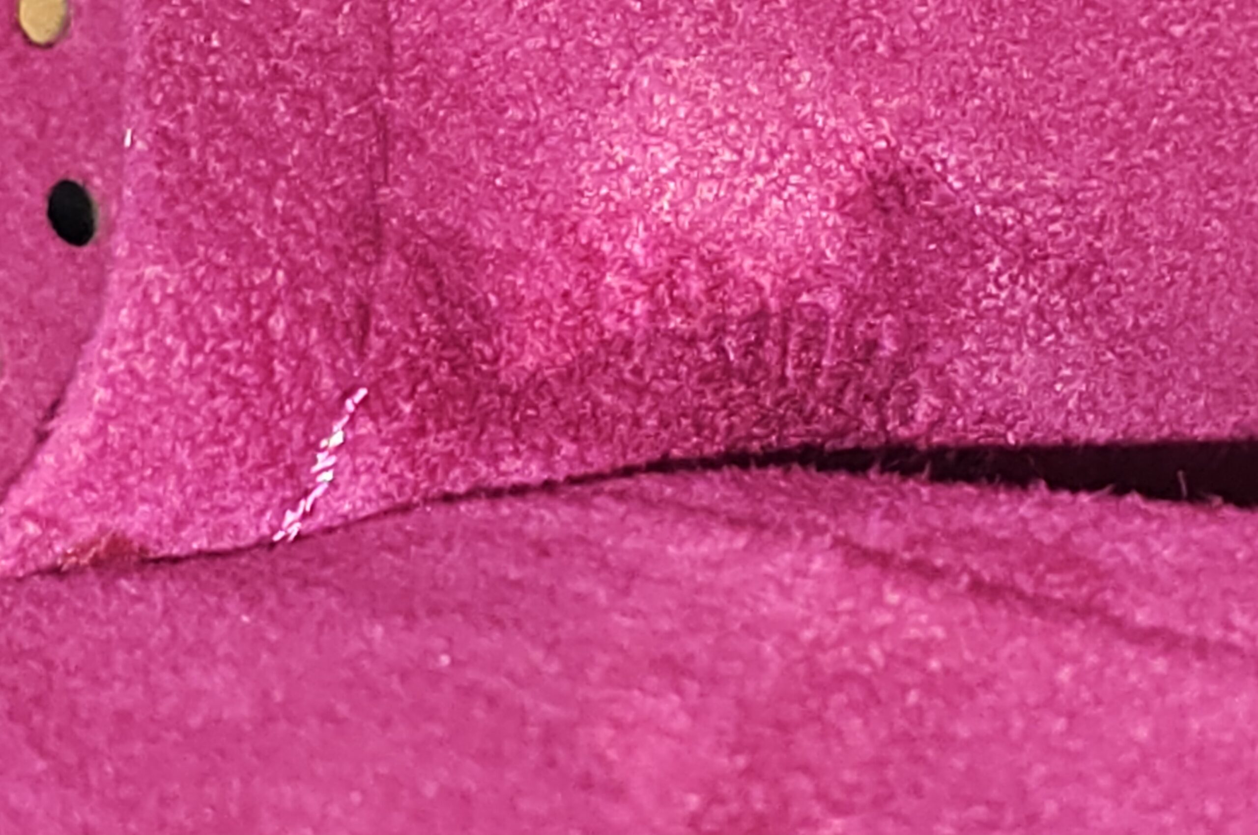 Close-up of the fuchsia interior of the Louis Vuitton Monogram Perforated Musette showing light signs of use