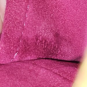 Fuchsia suede-like interior of the Louis Vuitton Monogram Perforated Musette shown close up for condition