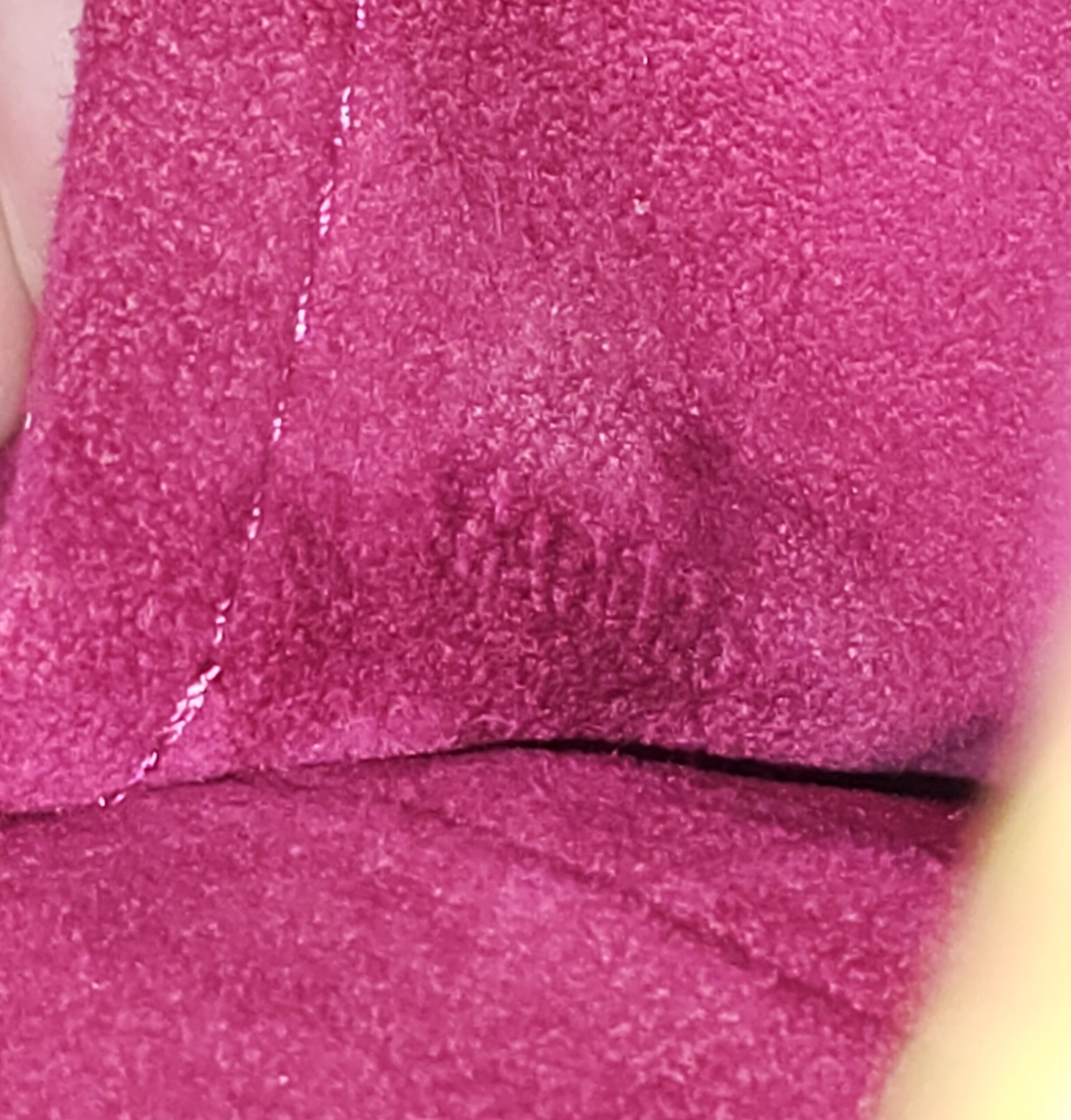 Fuchsia suede-like interior of the Louis Vuitton Monogram Perforated Musette shown close up for condition