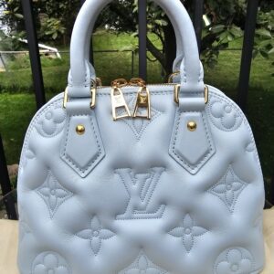 Front view of the Louis Vuitton Bubblegram Alma BB in Ice Blue with padded Monogram stitching and gold hardware