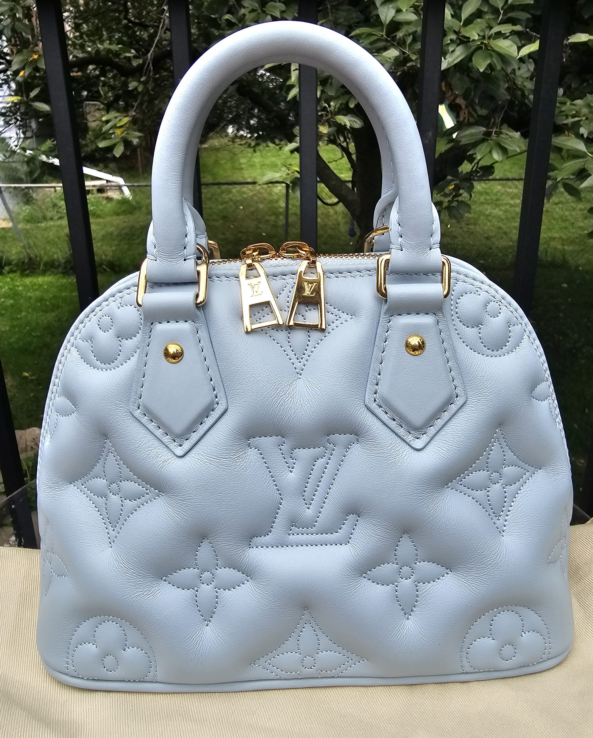 Front view of the Louis Vuitton Bubblegram Alma BB in Ice Blue with padded Monogram stitching and gold hardware