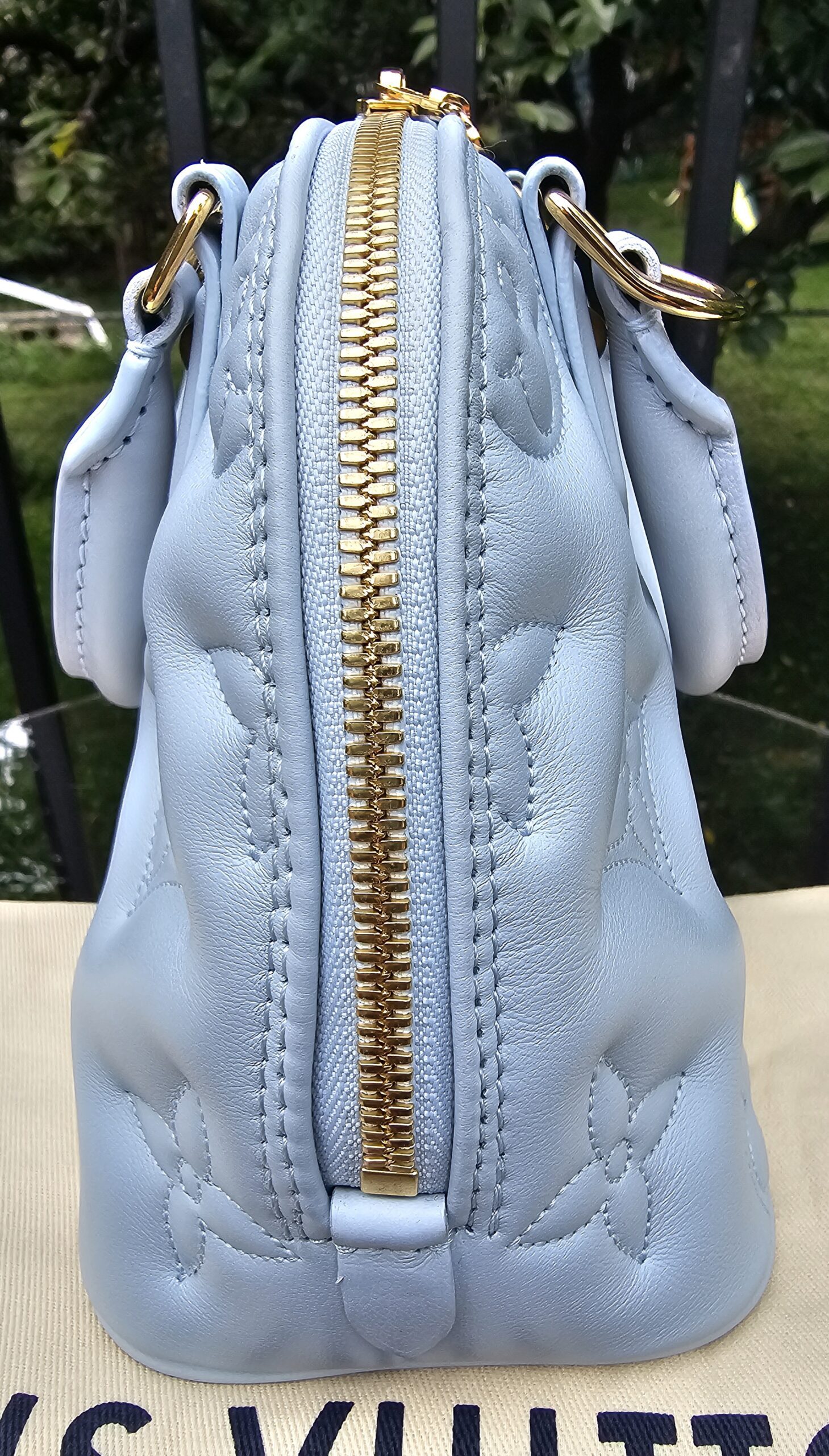 Gold-tone double zip closure along the top of the Louis Vuitton Bubblegram Alma BB