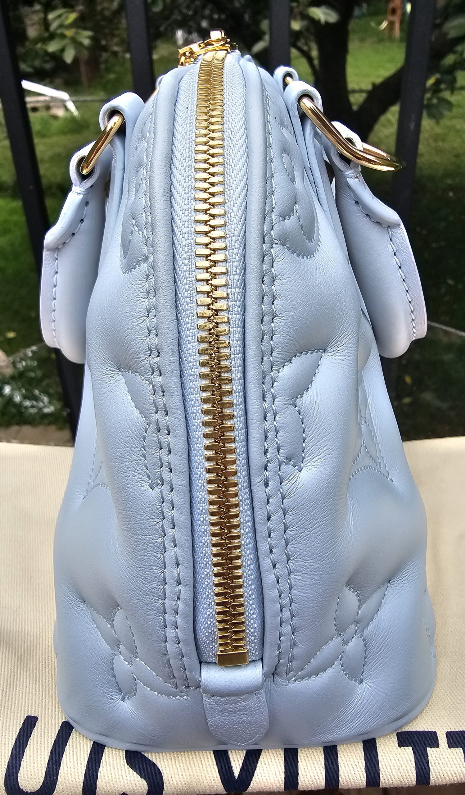 Side profile of the Louis Vuitton Bubblegram Alma BB in Ice Blue calfskin
