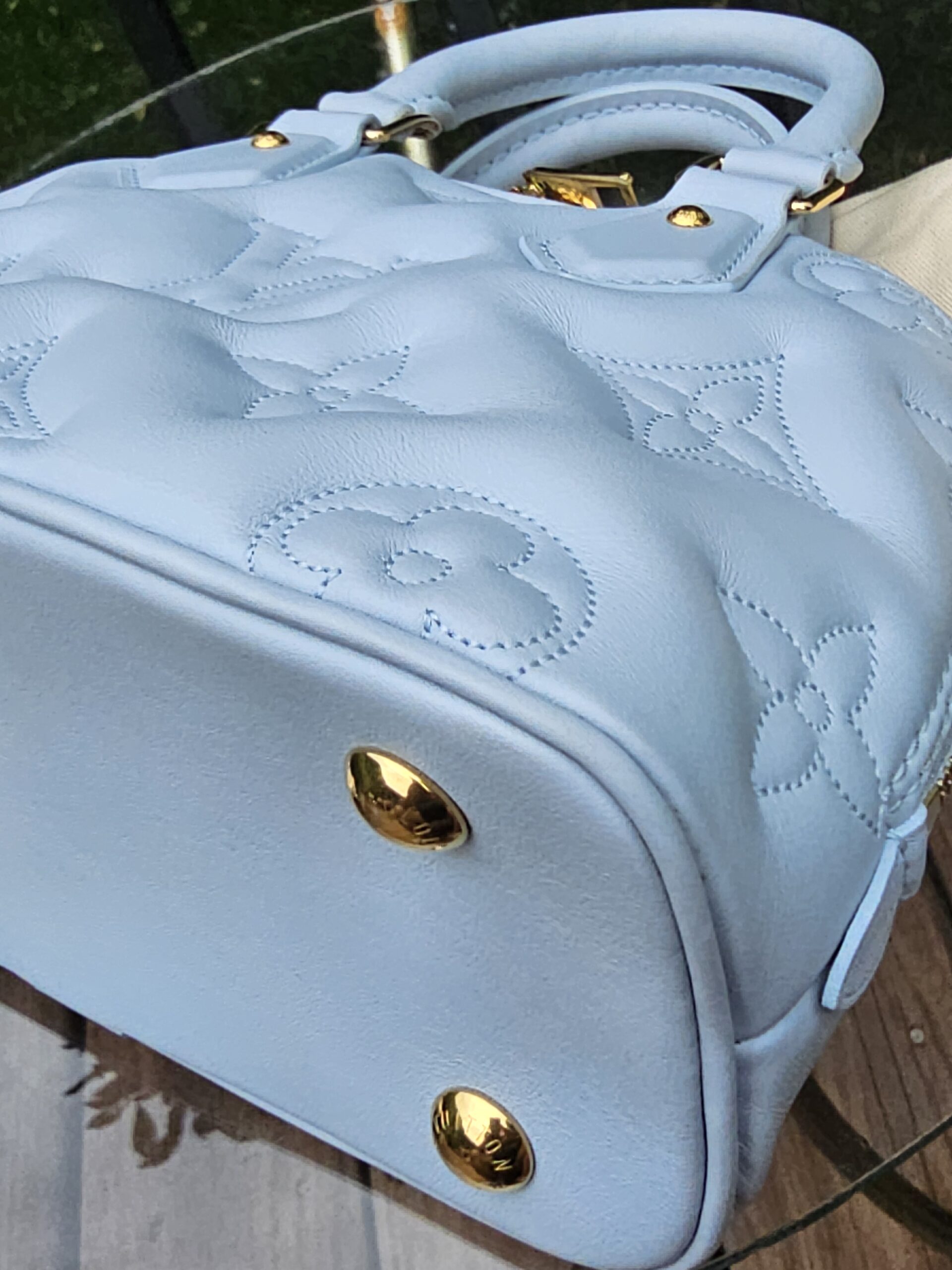 Corner of the Louis Vuitton Bubblegram Alma BB shown for condition