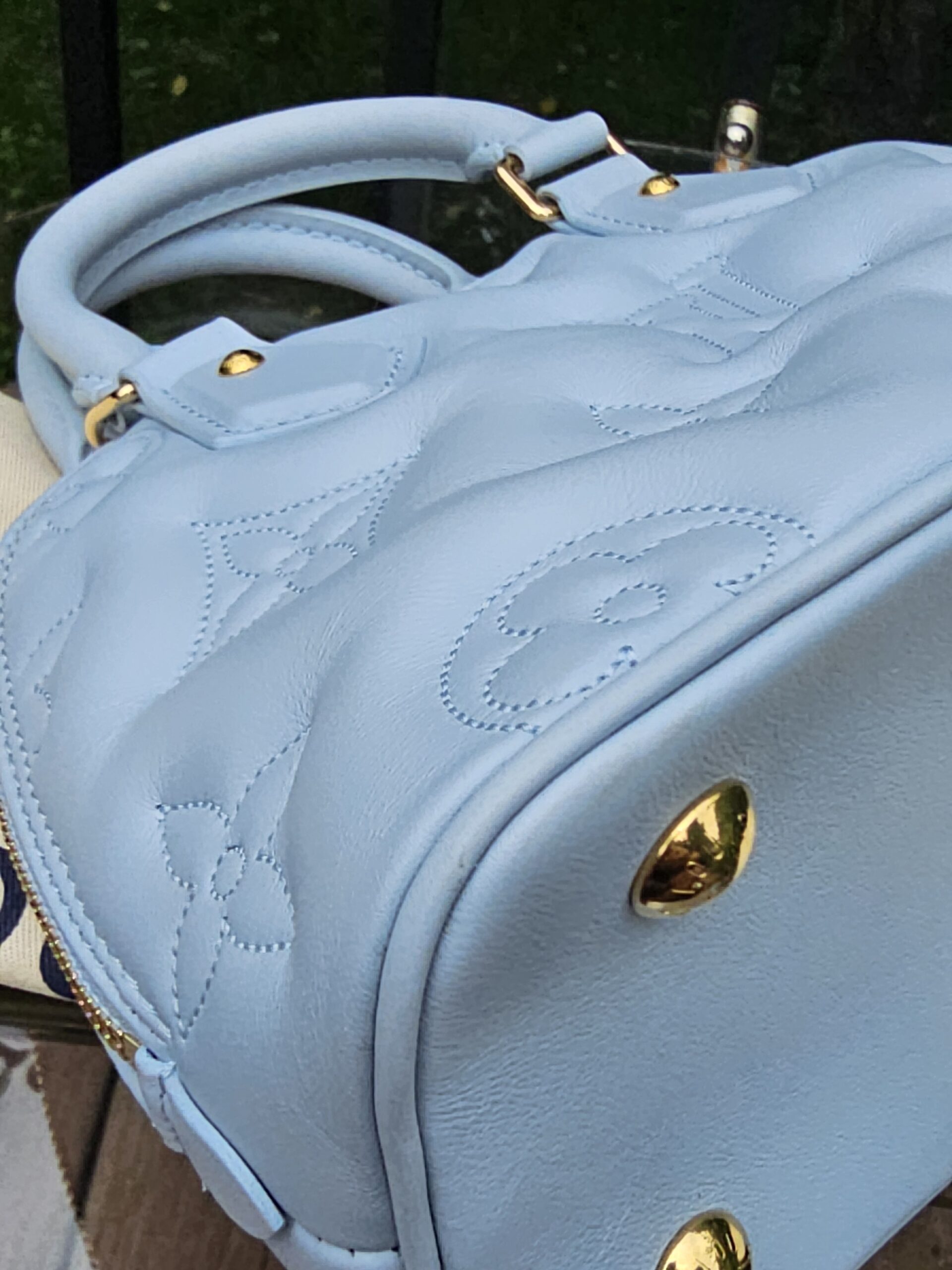 Oversized stitched Monogram detailing on the Ice Blue Bubblegram calfskin of the Alma BB