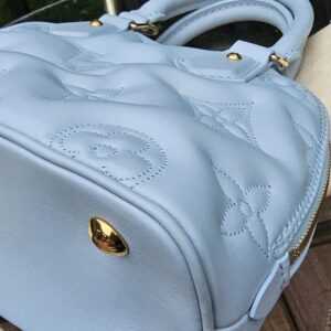 Rolled leather top handles of the Louis Vuitton Bubblegram Alma BB in Ice Blue