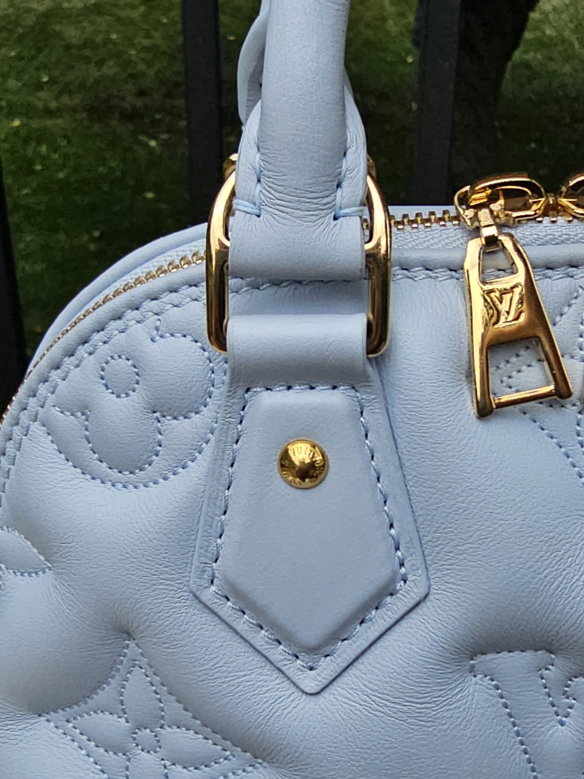 Gold-tone handle attachment hardware on the Louis Vuitton Bubblegram Alma BB