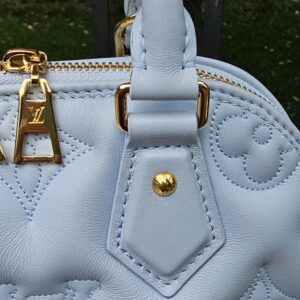 Close-up of the gold-tone hardware where the handles meet the Louis Vuitton Bubblegram Alma BB