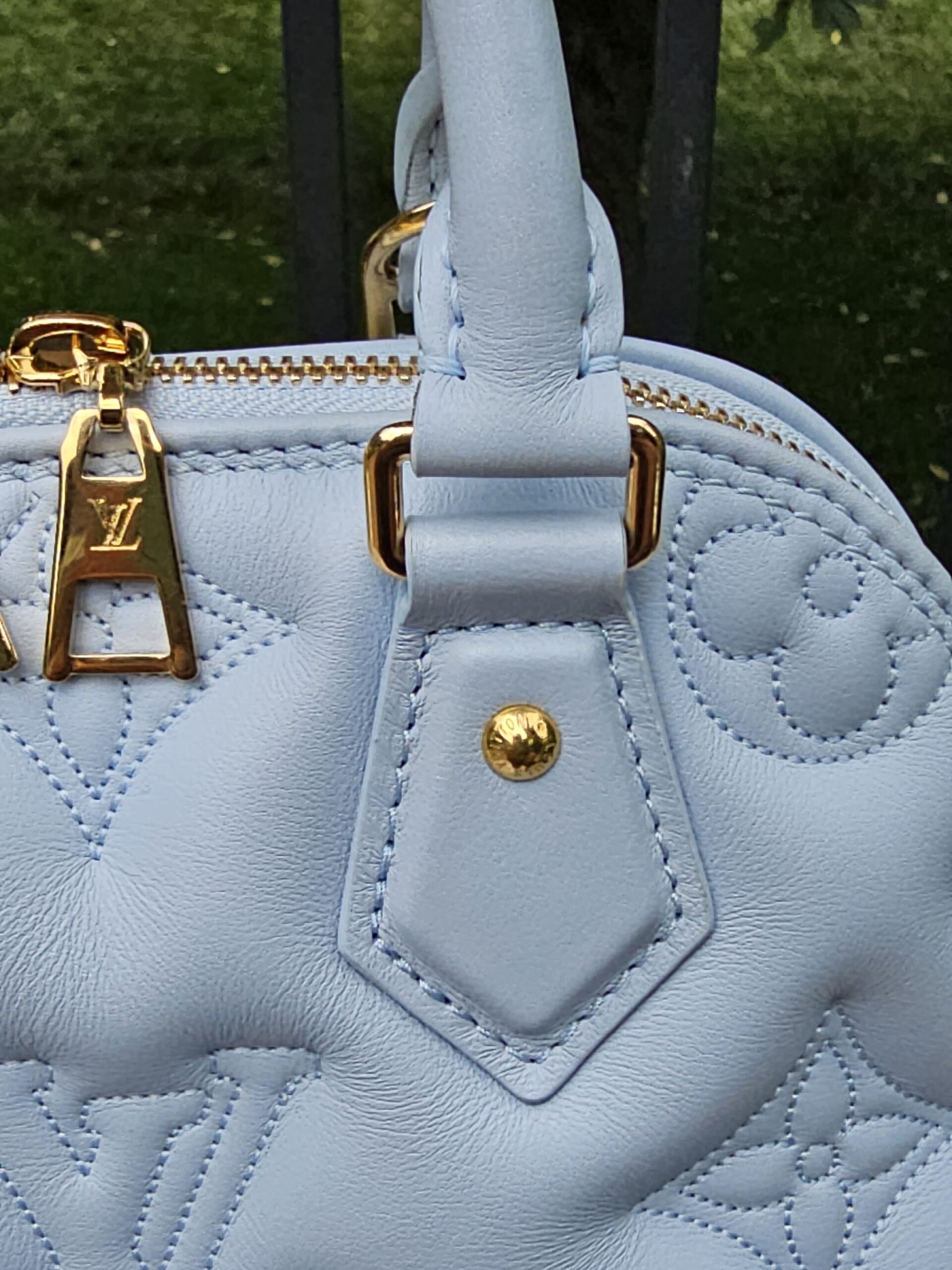 Close-up of the gold-tone hardware where the handles meet the Louis Vuitton Bubblegram Alma BB