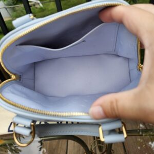 Louis Vuitton Bubblegram Alma BB held open showing the clean Monogram textile interior