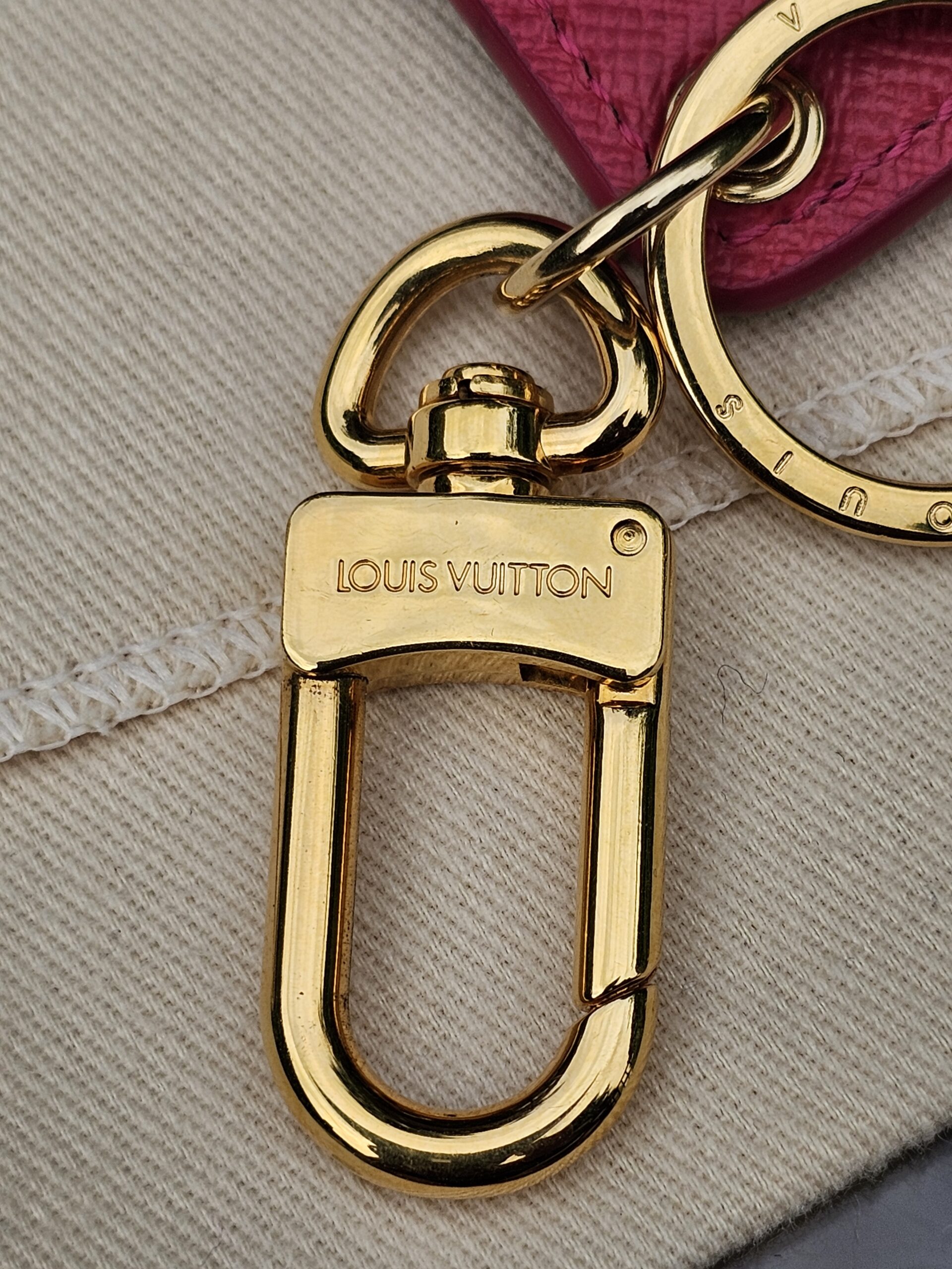 Gold-tone clasp stamped Louis Vuitton on the Illustre Pink Carousel key holder