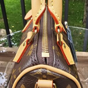 Side profile of the Louis Vuitton Nano Speedy Bandouliere showing the zip closure, piping and gold-tone D-ring