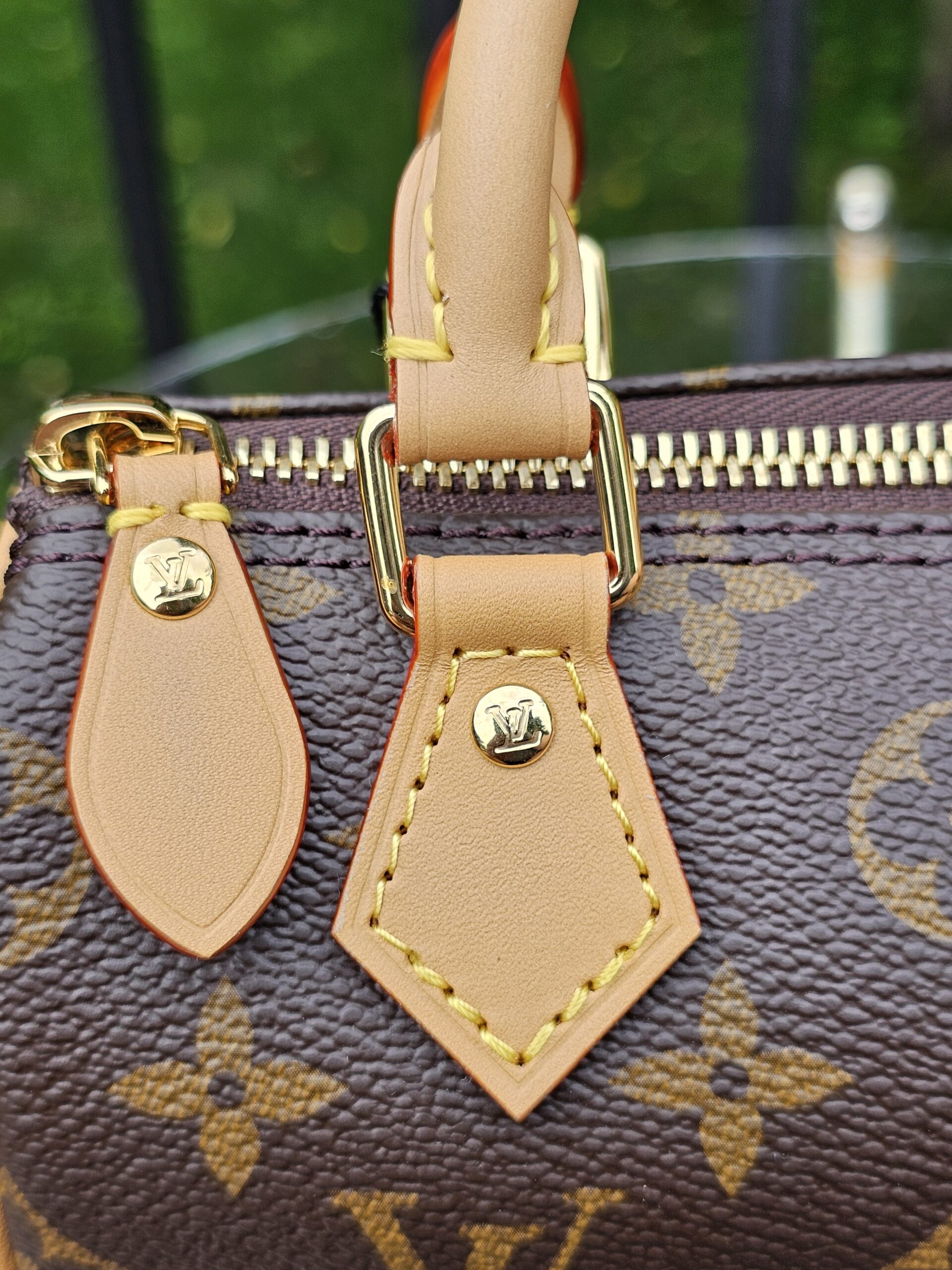 Twin vachetta leather zipper pulls and gold-tone hardware on the Louis Vuitton Nano Speedy Bandouliere